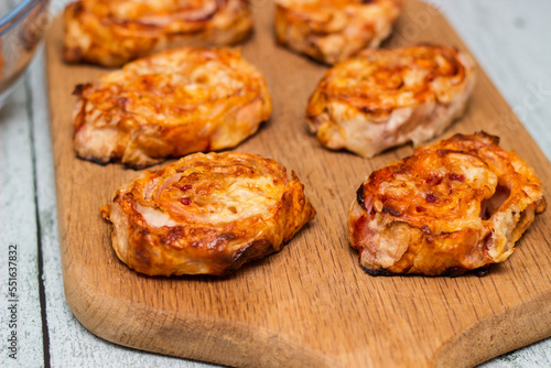 Homemade mini pizza buns topped with tomato sauce, ham and cheese