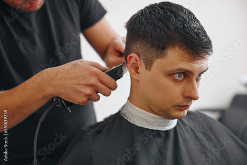 Barber shaving caucasian man in barber shop