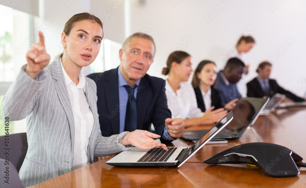 Fototapeta premium Mature businessman prompts and helps businesswoman during a business meeting