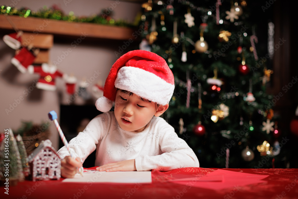 young girl wearing santa hat was writing letter to Santa at home young girl wearing santa hat was writing letter to Santa at home