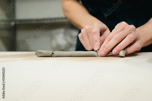 Close up of potter cutting a handle from clay in ceramic studio