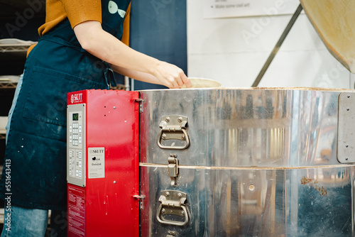 Foto Potter unloading ceramic kiln in studio. Woman potter hands.