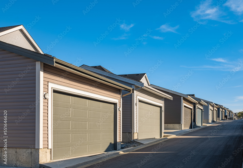 Row of garage doors at parking area for townhouses. Private garages for storage or cars in rows in Canada Row of garage doors at parking area for townhouses. Private garages for storage or cars in rows in Canada