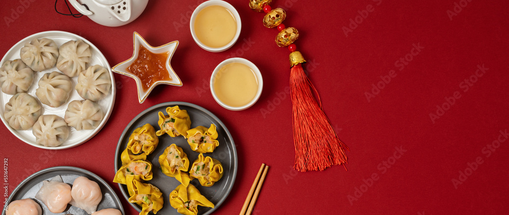 Chinese new year festival table over red background. Traditional lunar new year food. Flat lay, top view. Banner