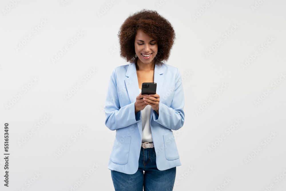 Smiling African American business woman using mobile phone reading text message isolated on background. Technology concept Smiling African American business woman using mobile phone reading text message isolated on background. Technology concept