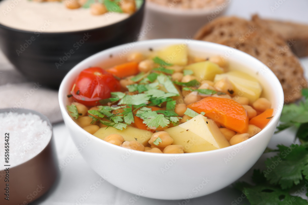 Tasty chickpea soup in bowls on white table, closeup Tasty chickpea soup in bowls on white table, closeup