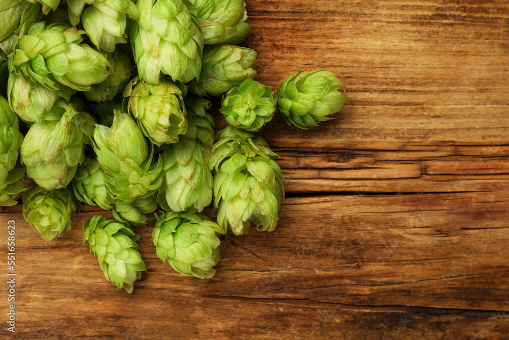Heap of fresh green hops on wooden table, flat lay. Space for text Heap of fresh green hops on wooden table, flat lay. Space for text