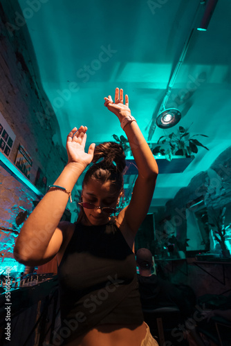 Photography Beautiful female DJ dancing to techno in a small club