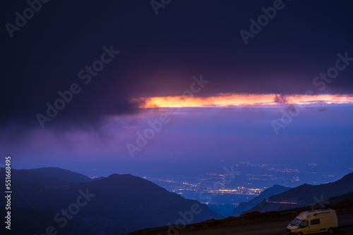 View of Sierra Nevada with small road and City of Granada at sunset