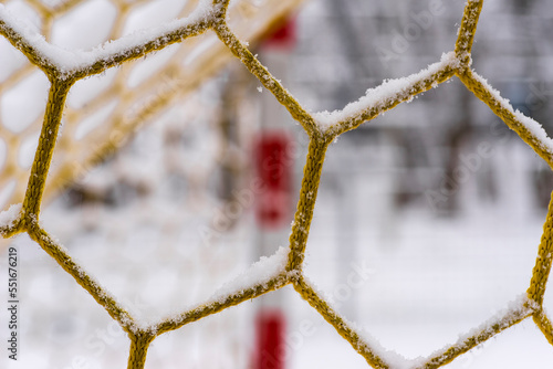 Ośmiokątne oczko siatki w bramce do piłki nożnej . Śnieg na bramce .