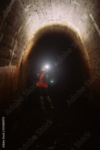 Female digger with flashlight explores the tunnel