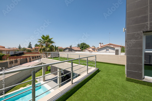 Covered terrace with artificial grass overlooking a summer pool © Toyakisfoto.photos