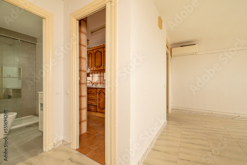 Empty living room of a house with stoneware floors of different shades and access to different rooms