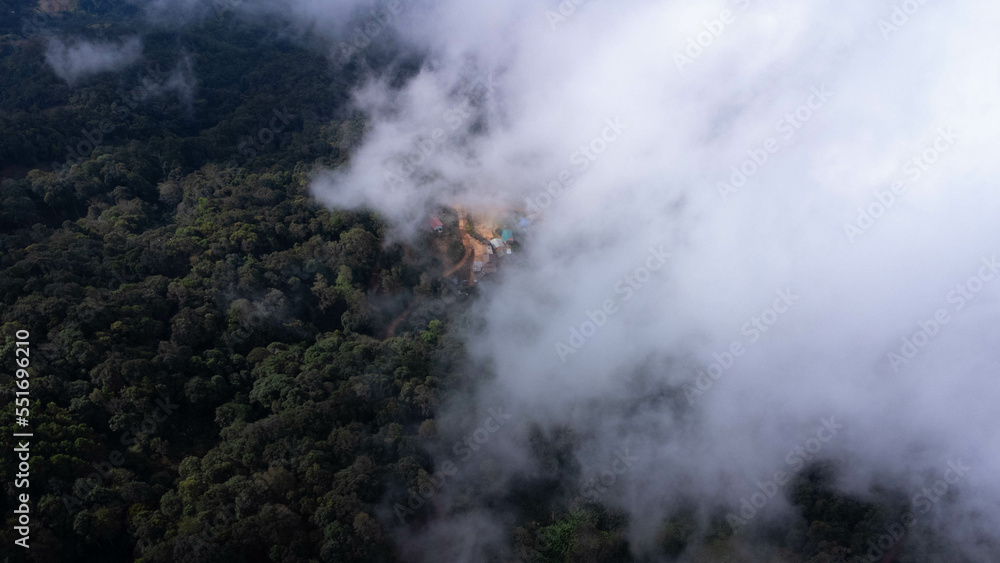Aerial view of tropical forest with mist in the morning. Top view from drone of beautiful mountain tropical forest during winter in Thailand. Natural landscape background. Aerial view of tropical forest with mist in the morning. Top view from drone of beautiful mountain tropical forest during winter in Thailand. Natural landscape background.