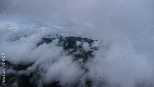Aerial view of tropical forest with mist in the morning. Top view from drone of beautiful mountain tropical forest during winter in Thailand. Natural landscape background. © Pornpimon