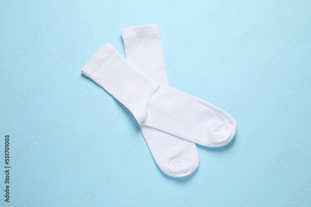 Pair of white socks on light blue background, flat lay Pair of white socks on light blue background, flat lay