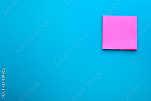 Paper note on blue background, top view. Space for text