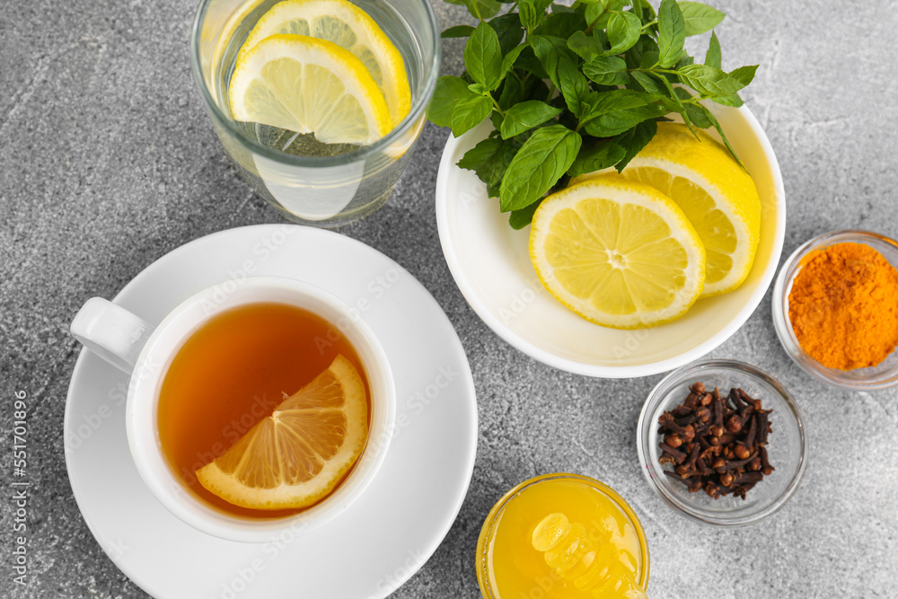 Cup with delicious immunity boosting tea and ingredients on grey table, flat lay Cup with delicious immunity boosting tea and ingredients on grey table, flat lay