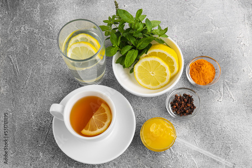 Cup with delicious immunity boosting tea and ingredients on grey table, above view