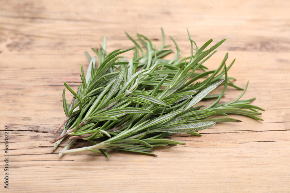 Sprigs of fresh rosemary on wooden table Sprigs of fresh rosemary on wooden table