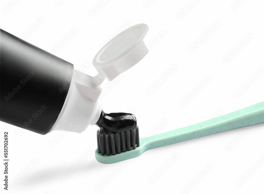 Tube of charcoal toothpaste and brush on white background Tube of charcoal toothpaste and brush on white background