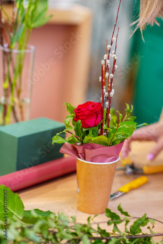 Hands of a florist creating a flower arrangement for Easter close-up
