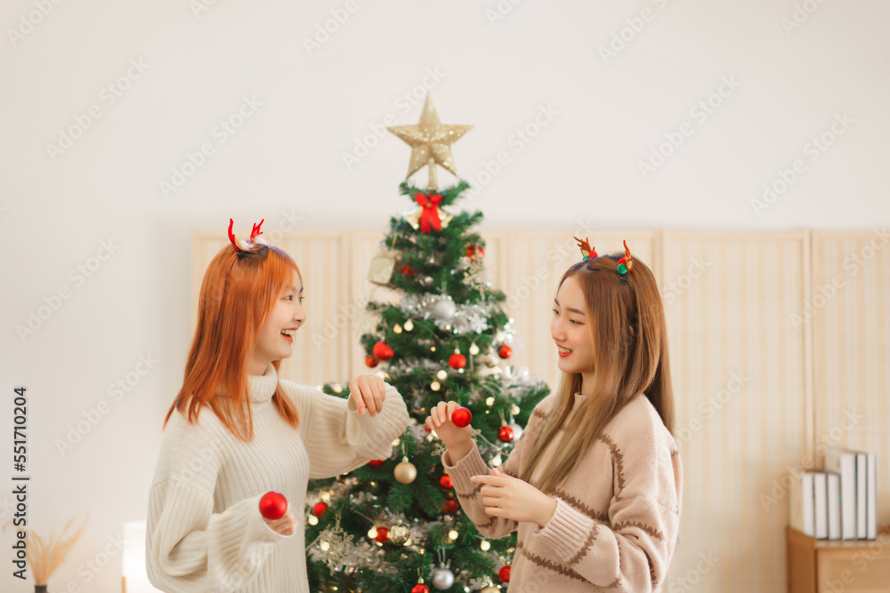 Christmas concept, Two women in reindeer horns to holding christmas ball and dancing with happiness