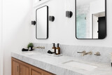 A cozy bathroom with a wood cabinet, marble countertop, and sconces around square mirrors. 