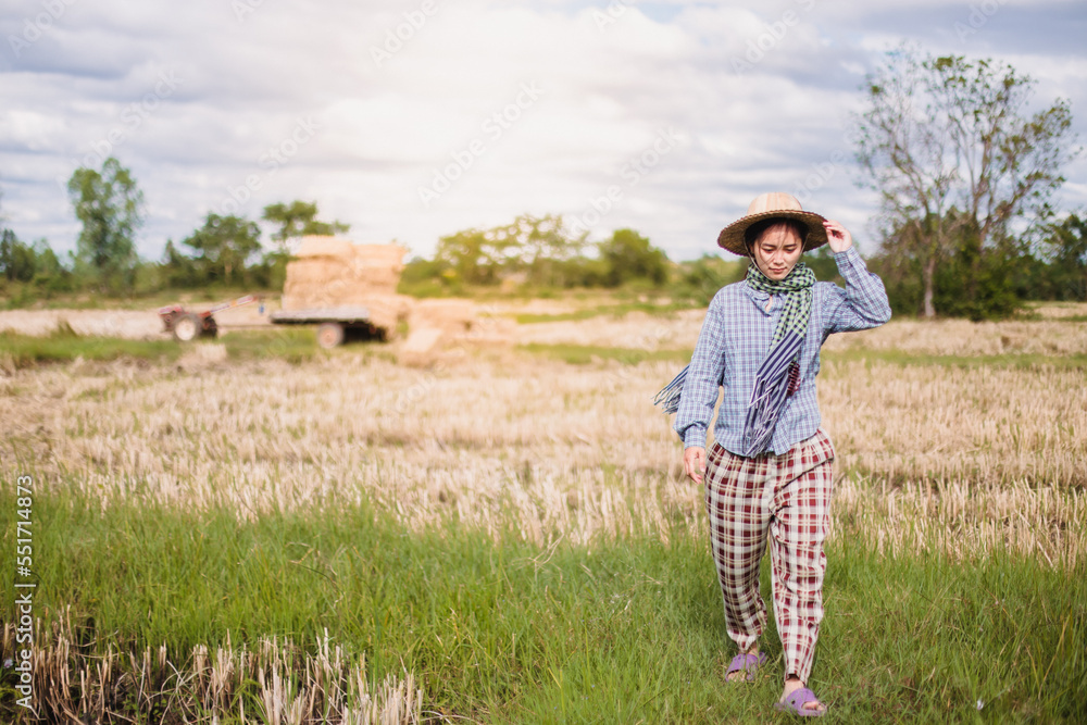 Young pretty farmer woman standing on farmland and inspecting agricultural crops