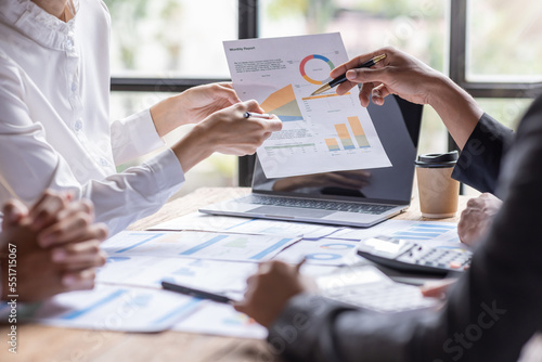 Group of confident business people point to graphs and charts to analyze market data, balance sheet, account, net profit to plan new sales strategies to increase production capacity. photo