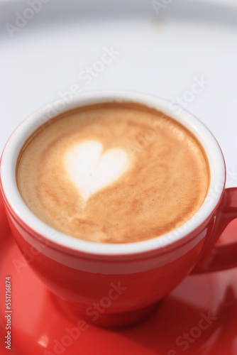 Cafe Latte Art, love shape on a cafe latte. Hot Cafe latte in a red cup