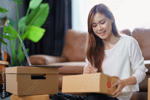 Starting small business entrepreneur of independent Asian female online seller packing products to send to customers and SME delivery concept