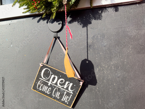 Foto A small wooden sign with the words Open come on in written in white text
