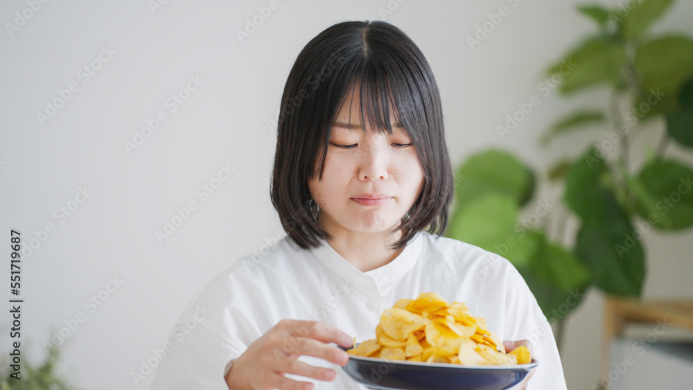 ポテトチップスを食べる女性(不健康・ダイエット).. ポテトチップスを食べる女性(不健康・ダイエット)..