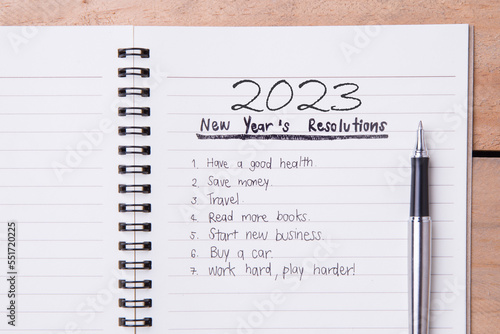 List of New Year's resolution on notepad, vintage style on wood with space for layout.