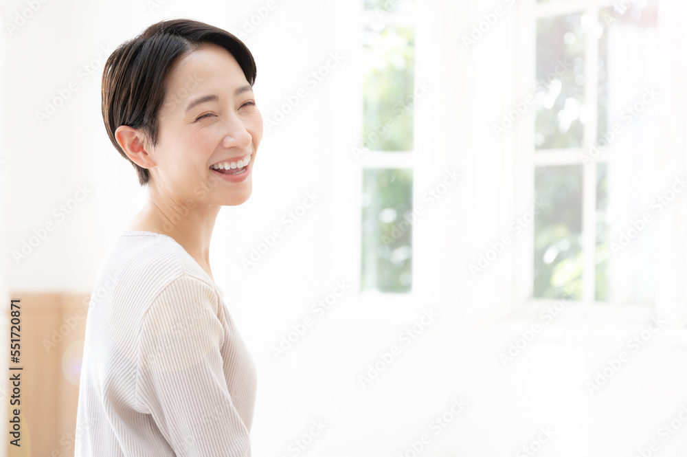 窓際で振り返って微笑む女性