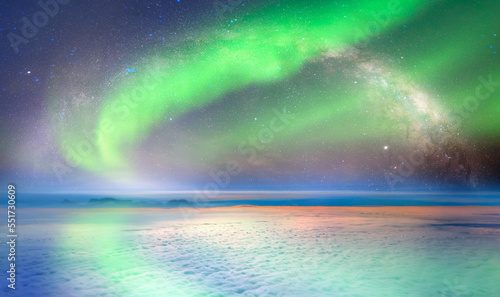 Amazing aurora borealis above the clouds with Milky Way galaxy
