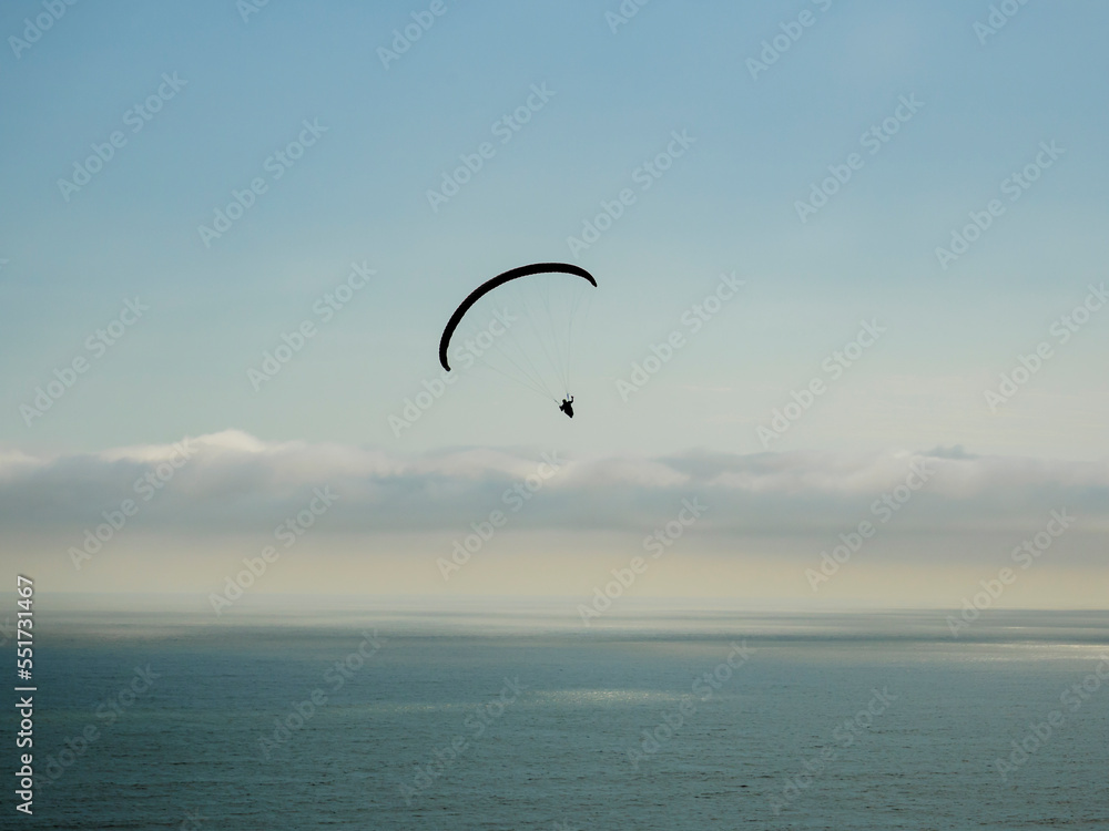 Silueta de vuelo en parapente sobre el océano pacifico, Perú, Sudamérica Silueta de vuelo en parapente sobre el océano pacifico, Perú, Sudamérica