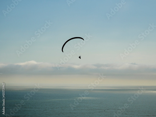 Silueta de vuelo en parapente sobre el océano pacifico, Perú, Sudamérica