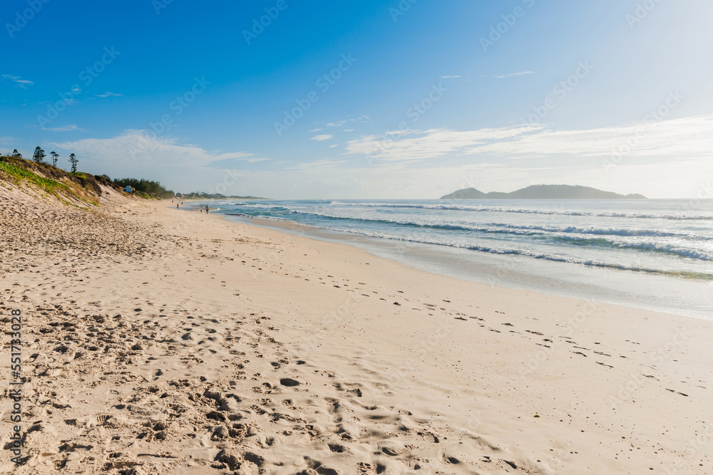 Morro das Pedras beach with ocean waves. Brazil beach with blue sky and sun light