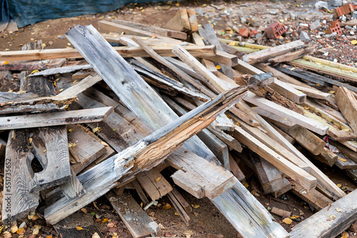 Remains of planks with nails after the installation of concrete formwork. Recycling of lumber. Background from scraps of old boards.