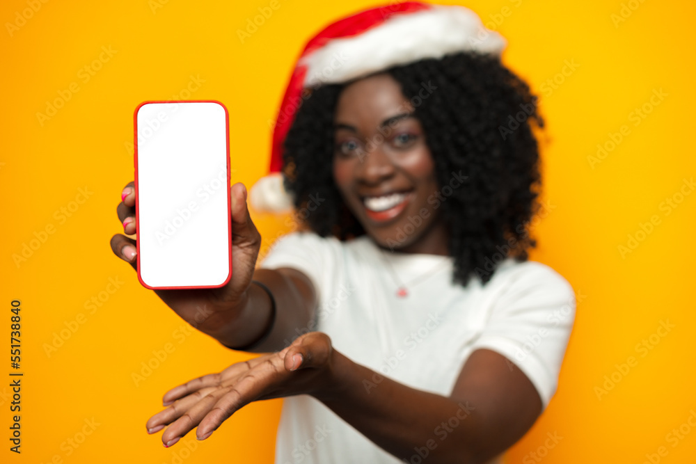 Beautiful african woman wearing santa hat with blank copyspace screen on phone Beautiful african woman wearing santa hat with blank copyspace screen on phone