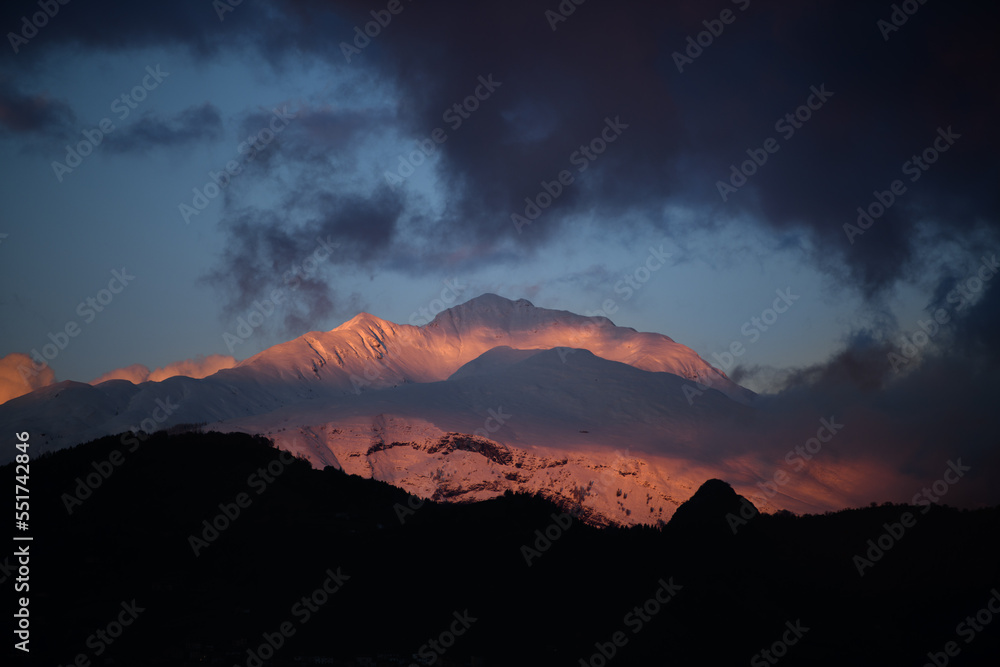 Snow-capped mountain illuminated by a pink sunset color