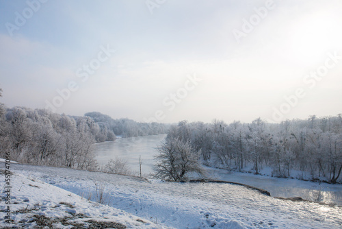 A wonderful view of the frozen forest and the icy river in the high hill