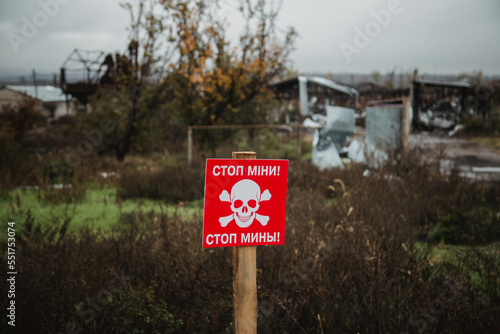 White skull-and-crossbones symbol on a red sign warning of the danger of landmines. Translation: "Stop mines!", war in Ukraine 2022