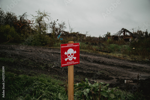 White skull-and-crossbones symbol on a red sign warning of the danger of landmines. Translation: "Stop mines!", war in Ukraine 2022