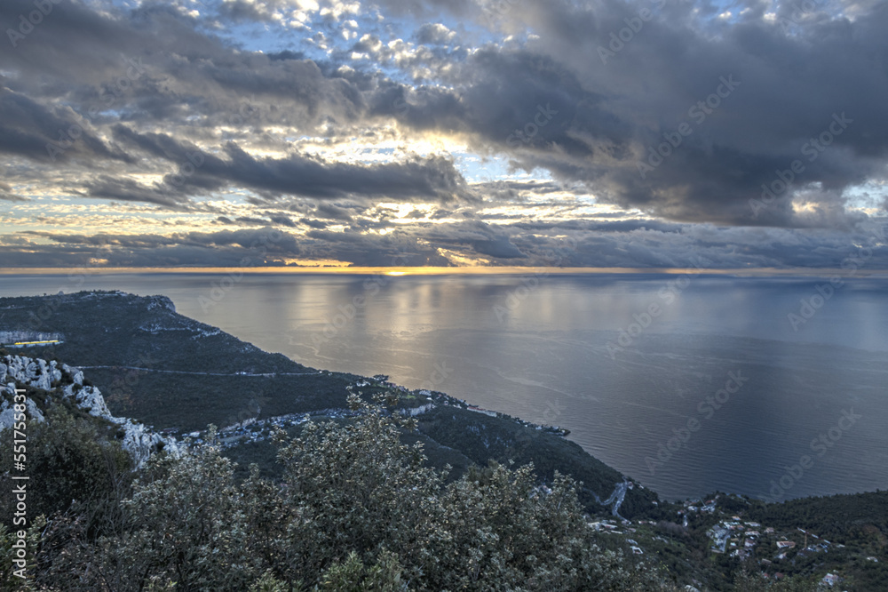 Obraz premium Panorama en bord de mer sur la Côte d'Azur avec comme paysage un ciel menaçant et un coucher de soleil et des falaises