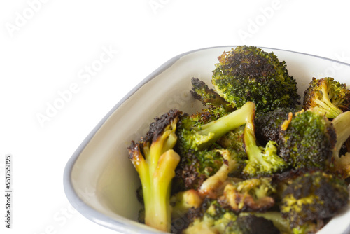 broccoli, oven roasted in olive oil,  in an enamel dish bowl. Isolated on a white background