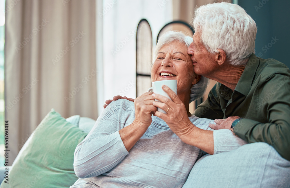 Kiss, coffee and senior couple laughing, talking and smile during retirement in the living room of their house. Relax, love and elderly man and woman with affection, tea drink and comic conversation Kiss, coffee and senior couple laughing, talking and smile during retirement in the living room of their house. Relax, love and elderly man and woman with affection, tea drink and comic conversation