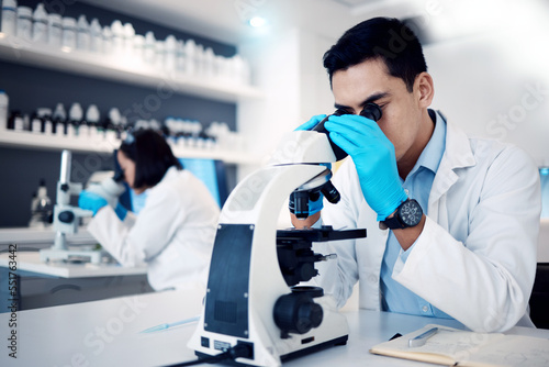 Science, research and man with medical microscope for exam, analysis and sample study in laboratory. Healthcare, medicine and male scientist use equipment for lab test, analytics and biotechnology